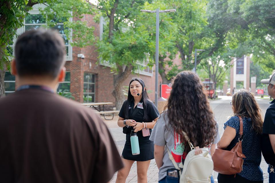 Campus tour guide giving a tour to students and parents